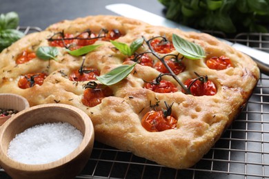 Photo of Delicious focaccia with tomatoes and spices on table, closeup