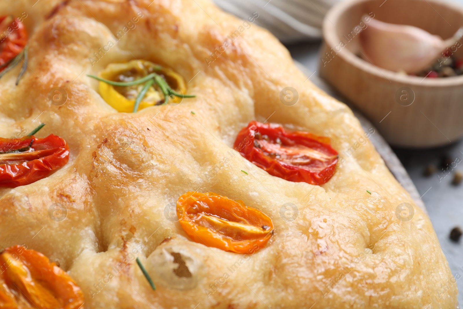 Delicious focaccia with tomatoes and rosemary on table, closeup Photo of Delicious focaccia with tomatoes and rosemary on table, closeup