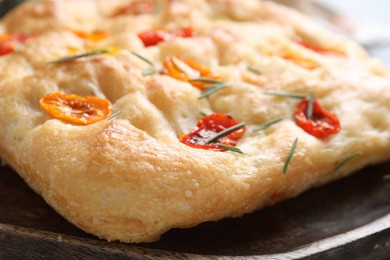 Photo of Delicious focaccia with tomatoes and rosemary on table, closeup