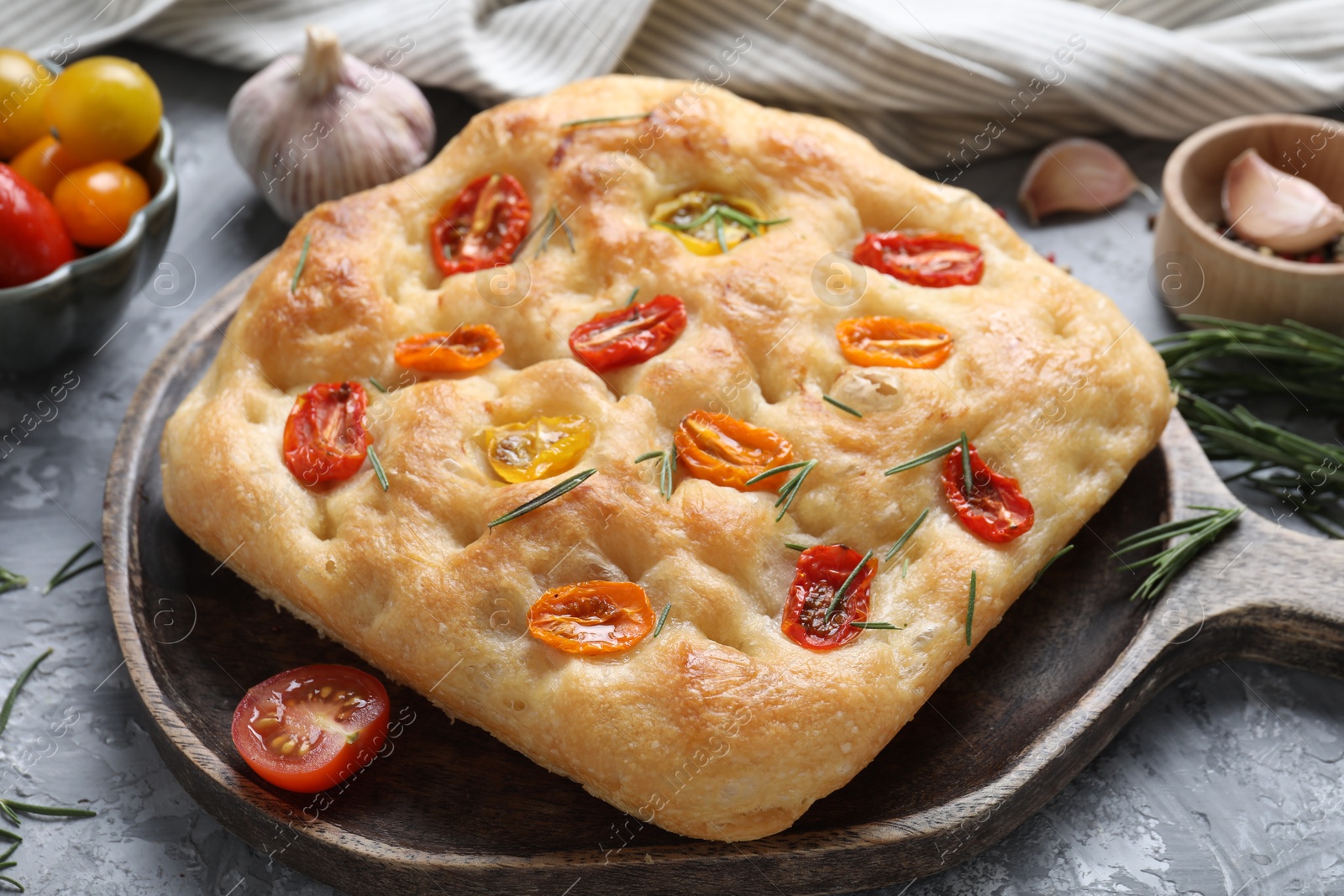 Delicious focaccia with tomatoes and spices on table, closeup Photo of Delicious focaccia with tomatoes and spices on table, closeup