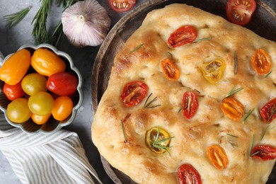 Photo of Delicious focaccia with tomatoes and spices on table, flat lay