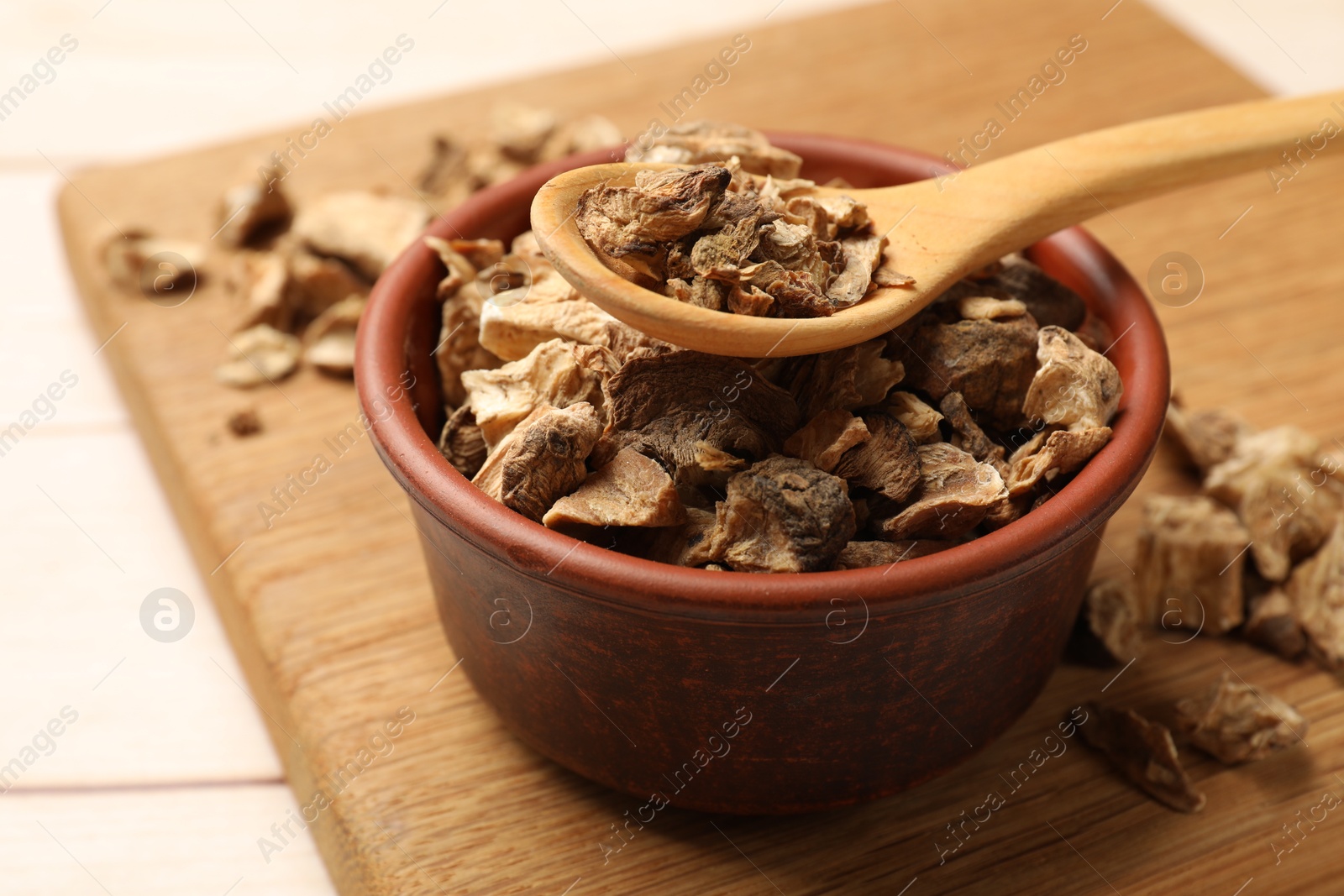 Pieces of dry chicory roots in bowl and spoon on table, closeup Photo of Pieces of dry chicory roots in bowl and spoon on table, closeup