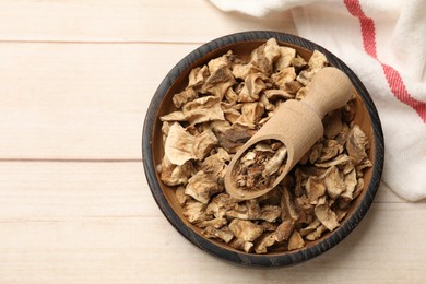 Photo of Pieces of dry chicory roots in bowl and scoop on wooden table, top view