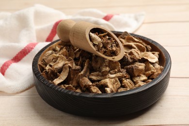 Photo of Pieces of dry chicory roots in bowl and scoop on wooden table, closeup