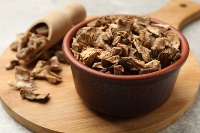 Photo of Pieces of dry chicory roots in bowl and scoop on gray table, closeup