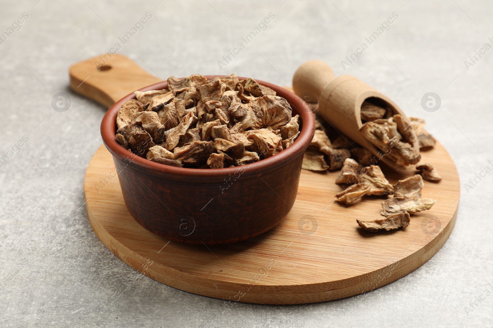 Pieces of dry chicory roots in bowl and scoop on gray textured table, closeup Photo of Pieces of dry chicory roots in bowl and scoop on gray textured table, closeup