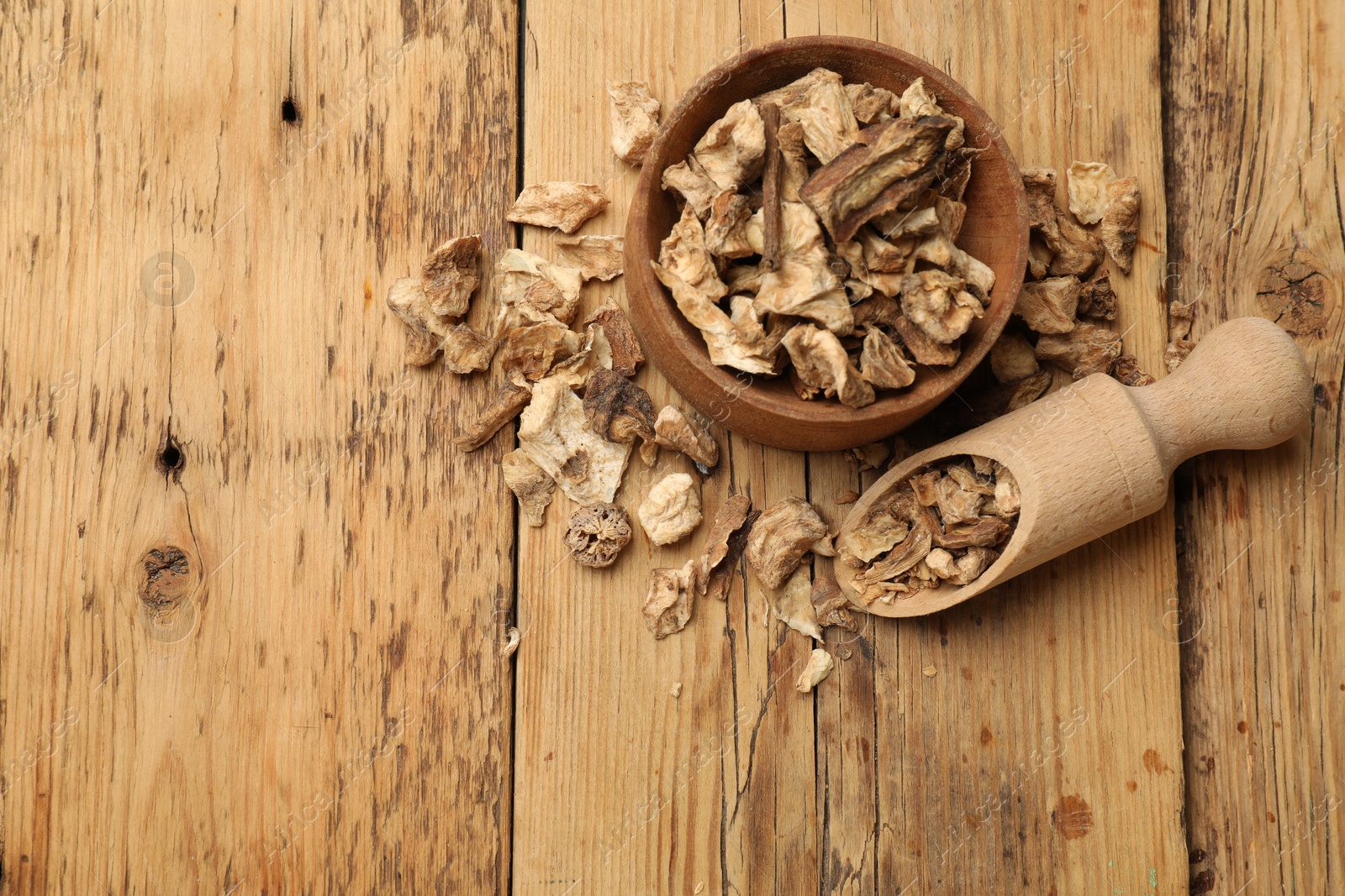 Pieces of dry chicory roots in bowl and scoop on wooden table, flat lay. Space for text Photo of Pieces of dry chicory roots in bowl and scoop on wooden table, flat lay. Space for text