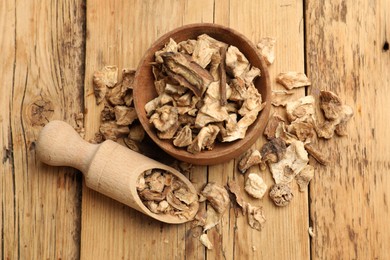 Photo of Pieces of dry chicory roots in bowl and scoop on wooden table, flat lay