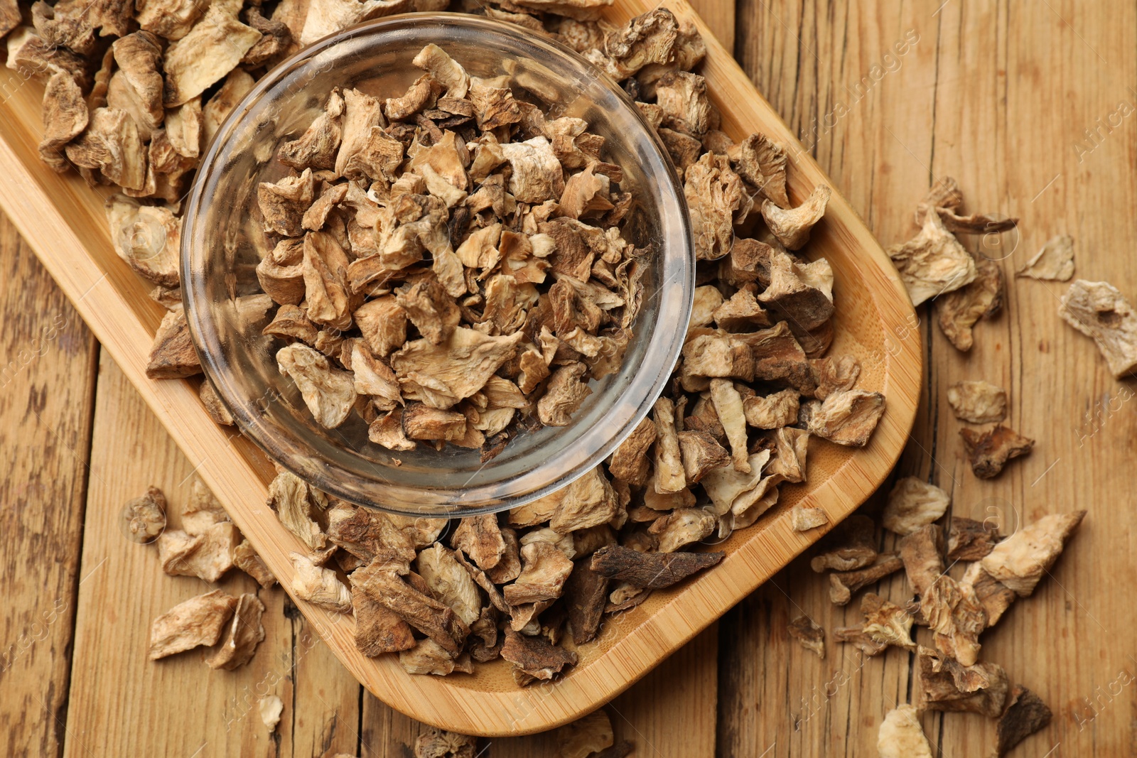 Pieces of dry chicory roots in bowl on wooden table, top view Photo of Pieces of dry chicory roots in bowl on wooden table, top view