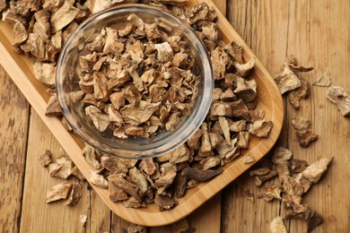 Photo of Pieces of dry chicory roots in bowl on wooden table, top view