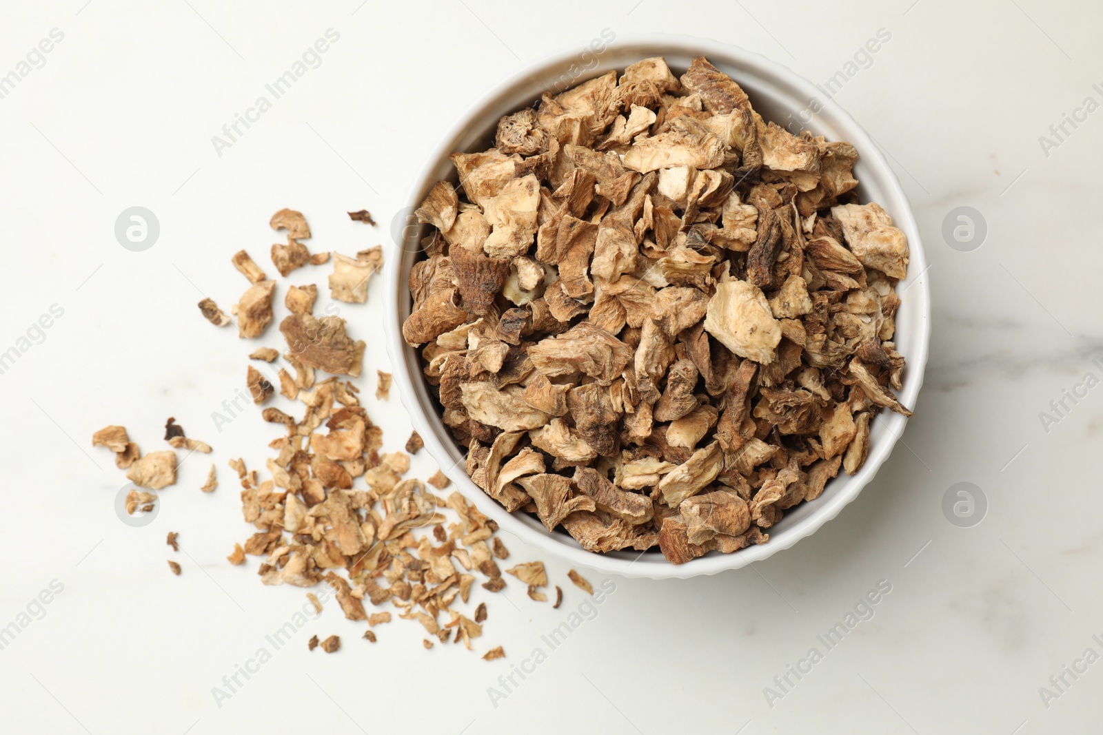 Pieces of dry chicory roots in bowl on white table, top view Photo of Pieces of dry chicory roots in bowl on white table, top view