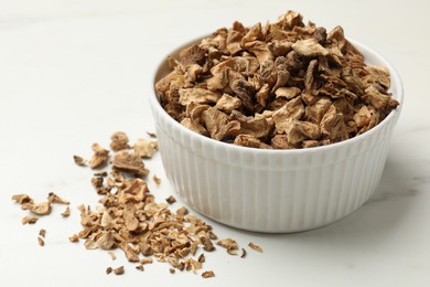 Photo of Pieces of dry chicory roots in bowl on white table, closeup