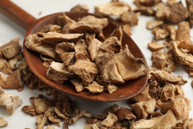 Photo of Pieces of dry chicory roots in spoon on white table, closeup