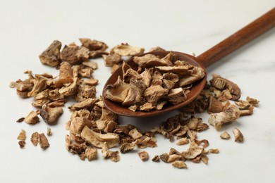 Photo of Pieces of dry chicory roots in spoon on white table, closeup