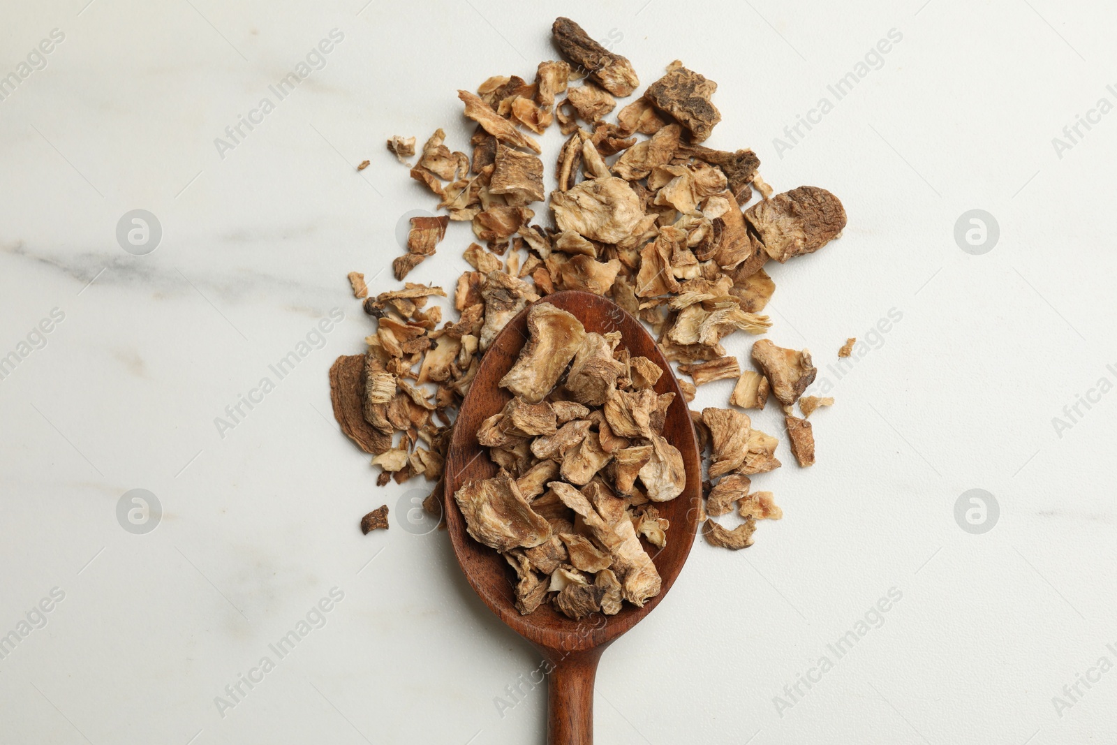 Pieces of dry chicory roots in spoon on white table, top view Photo of Pieces of dry chicory roots in spoon on white table, top view