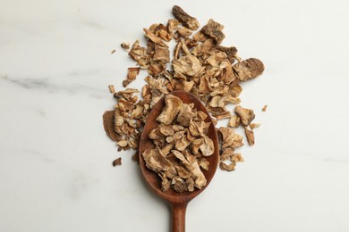Photo of Pieces of dry chicory roots in spoon on white table, top view