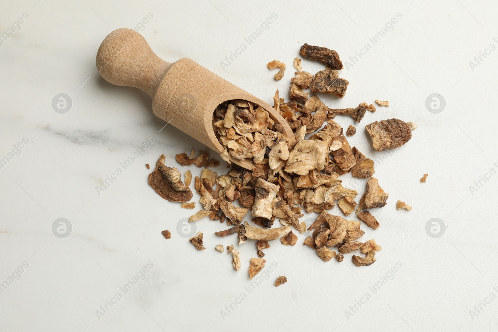 Pieces of dry chicory roots and scoop on white table, flat lay Photo of Pieces of dry chicory roots and scoop on white table, flat lay