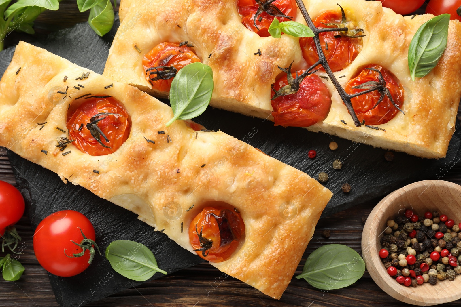 Pieces of delicious focaccia with tomatoes and spices on table, flat lay Photo of Pieces of delicious focaccia with tomatoes and spices on table, flat lay