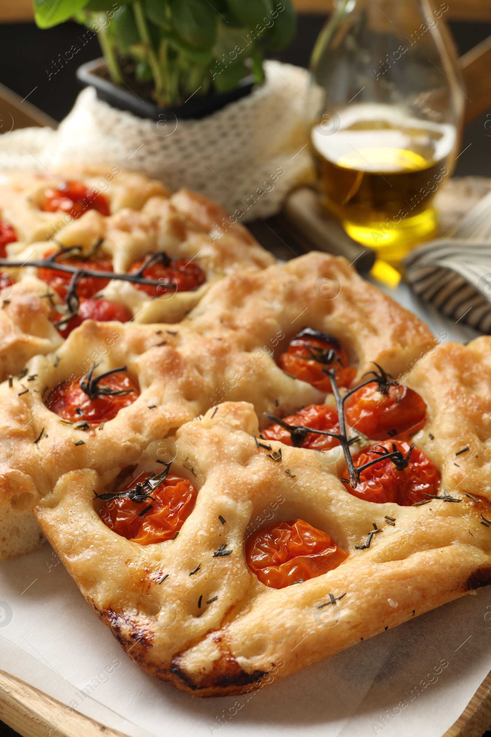 Cut delicious focaccia with tomatoes and spices on table, closeup Photo of Cut delicious focaccia with tomatoes and spices on table, closeup