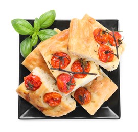 Photo of Pieces of delicious focaccia with tomatoes and basil isolated on white, top view