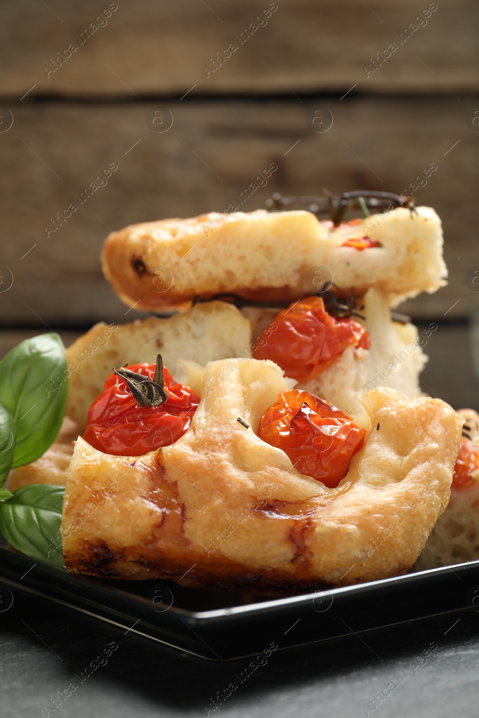 Pieces of delicious focaccia with tomatoes on table, closeup Photo of Pieces of delicious focaccia with tomatoes on table, closeup