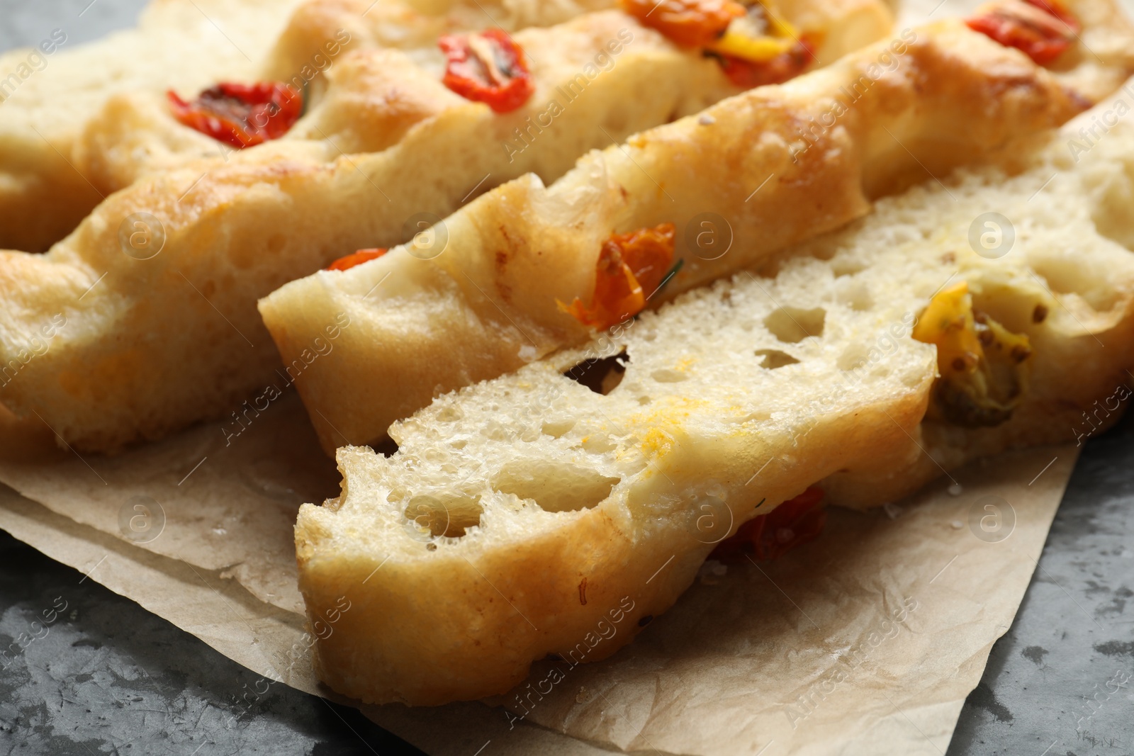 Pieces of delicious focaccia with tomatoes on table, closeup Photo of Pieces of delicious focaccia with tomatoes on table, closeup