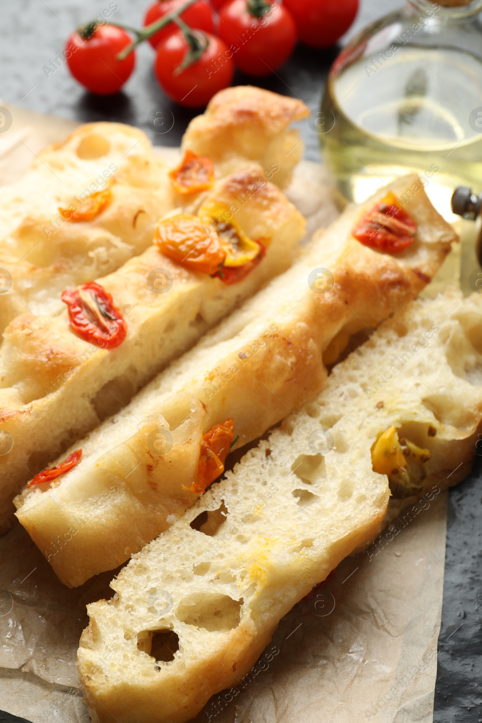 Pieces of delicious focaccia with tomatoes and oil on table, closeup Photo of Pieces of delicious focaccia with tomatoes and oil on table, closeup