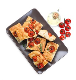 Photo of Pieces of delicious focaccia with tomatoes, spices and oil isolated on white, top view