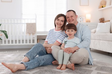 Photo of Cute little boy and his parents at home. Lovely family
