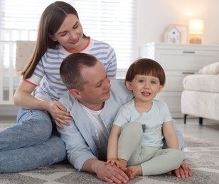 Photo of Cute little boy and his parents at home. Lovely family