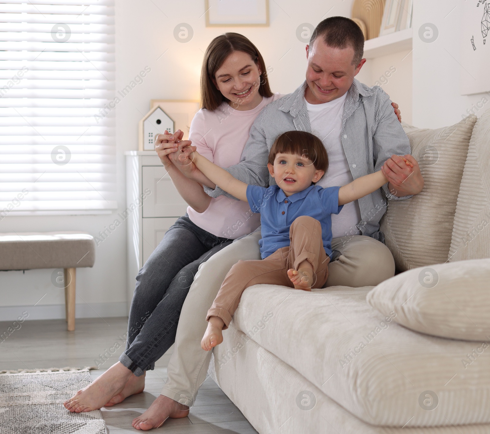 Cute little boy and his parents on sofa at home. Lovely family Photo of Cute little boy and his parents on sofa at home. Lovely family