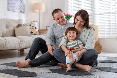 Photo of Cute little boy and his parents at home. Lovely family