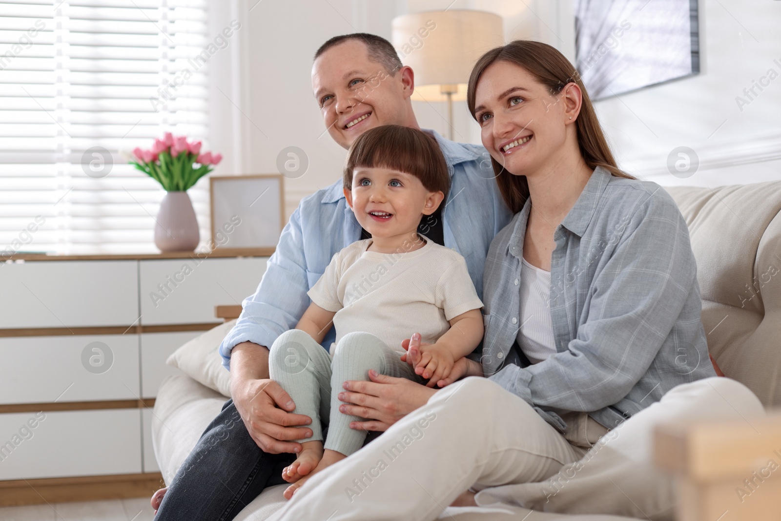 Cute little boy and his parents on sofa at home. Lovely family Photo of Cute little boy and his parents on sofa at home. Lovely family