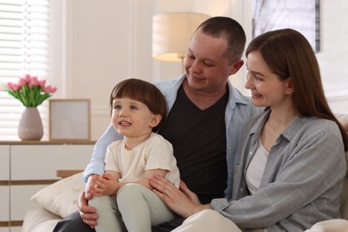 Photo of Cute little boy and his parents on sofa at home. Lovely family
