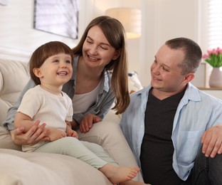 Photo of Cute little boy and his parents on sofa at home. Lovely family