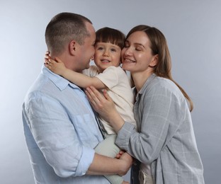 Photo of Happy parents and their baby boy on light grey background. Lovely family