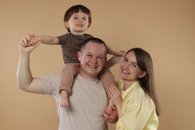 Photo of Happy parents and their baby boy on beige background. Lovely family