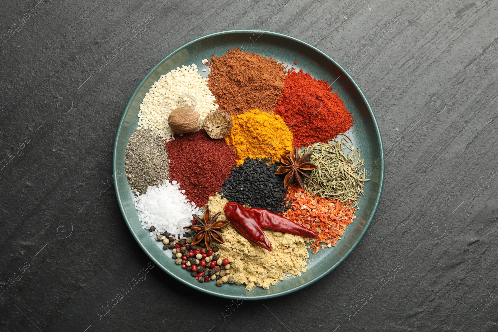 Different aromatic spices on dark textured background, top view Photo of Different aromatic spices on dark textured background, top view