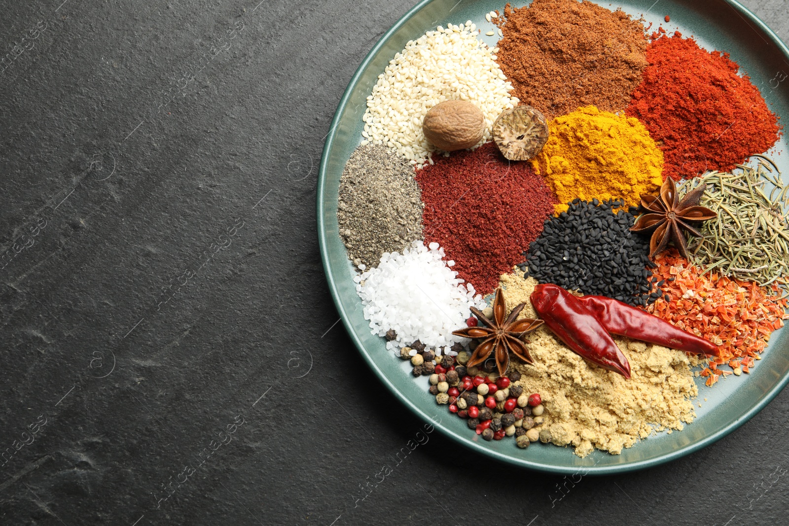 Different aromatic spices on dark textured table, top view. Space for text Photo of Different aromatic spices on dark textured table, top view. Space for text