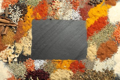 Photo of Different aromatic spices on dark textured table, top view. Space for text