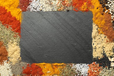 Photo of Different aromatic spices on dark textured table, top view. Space for text