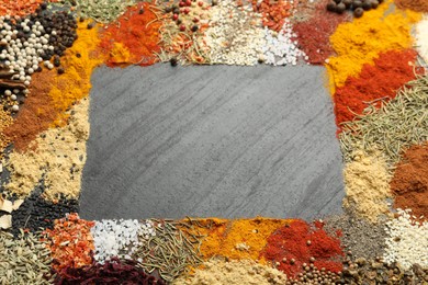 Photo of Different aromatic spices on dark textured table, top view. Space for text