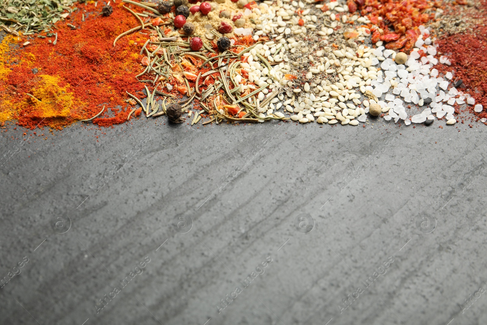 Different aromatic spices on dark textured table, top view. Space for text Photo of Different aromatic spices on dark textured table, top view. Space for text