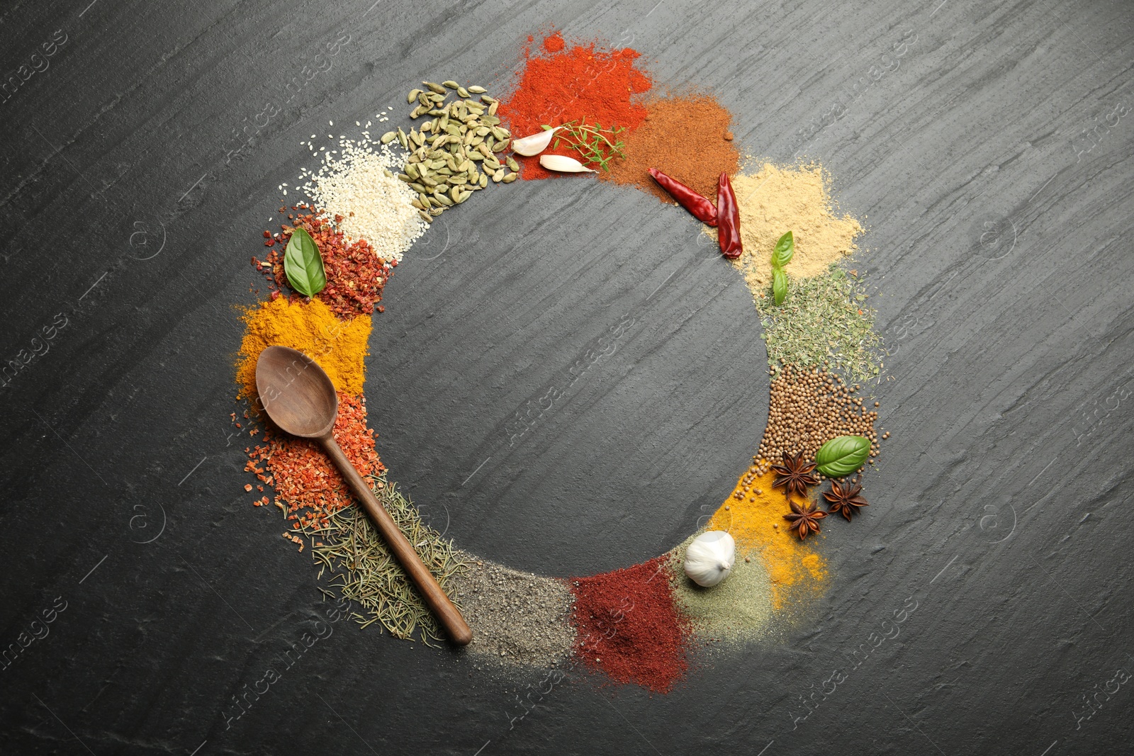 Different aromatic spices and spoon on dark textured table, top view. Space for text Photo of Different aromatic spices and spoon on dark textured table, top view. Space for text
