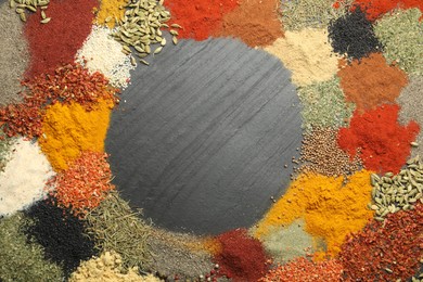Photo of Different aromatic spices on dark textured table, top view. Space for text