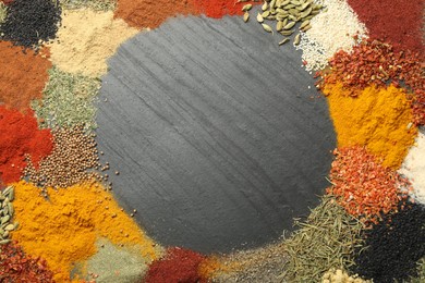 Photo of Different aromatic spices on dark textured table, top view. Space for text
