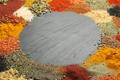 Photo of Different aromatic spices on dark textured table, closeup. Space for text