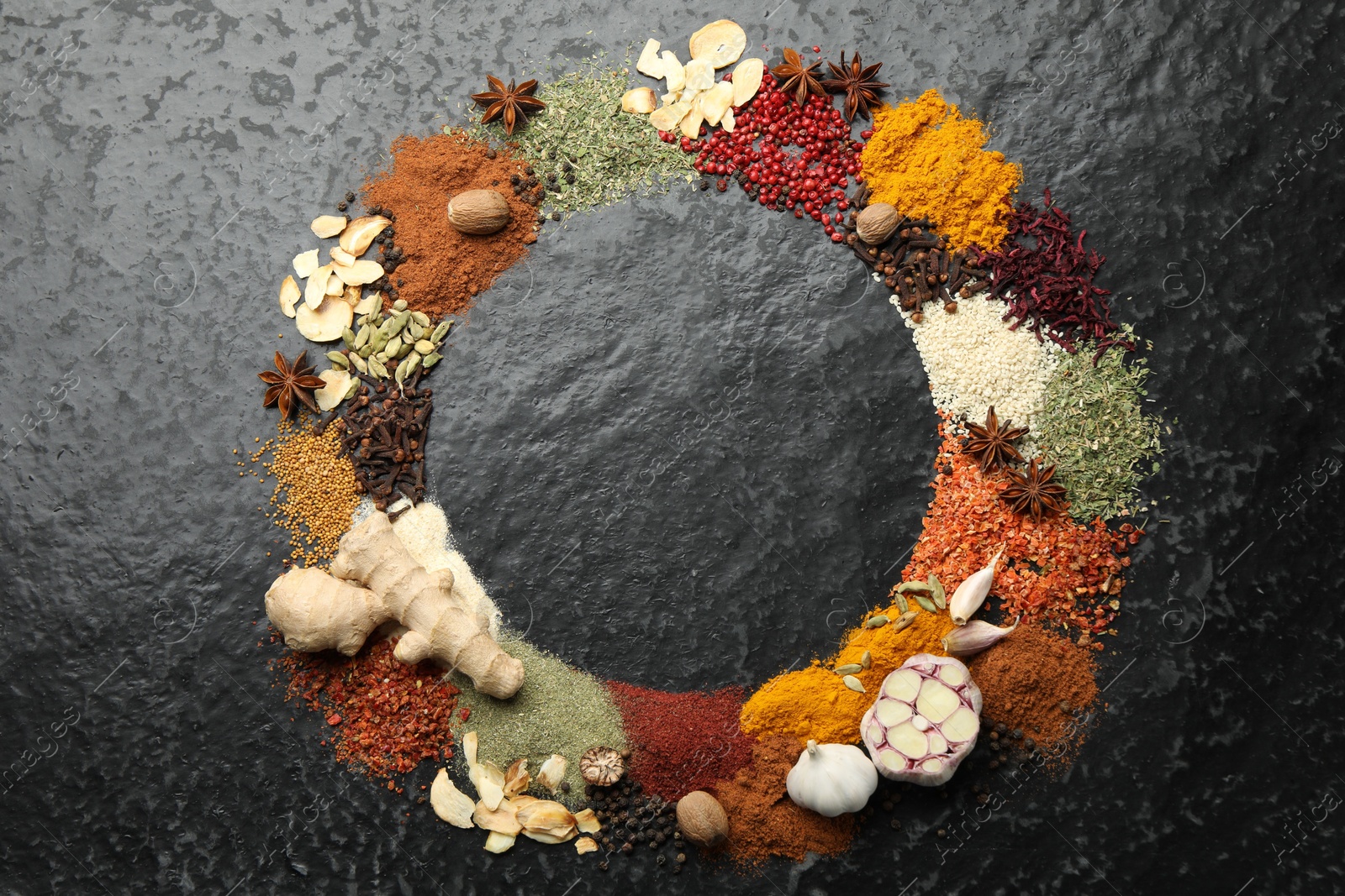 Different aromatic spices on dark textured table, top view. Space for text Photo of Different aromatic spices on dark textured table, top view. Space for text