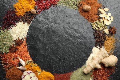 Photo of Different aromatic spices on dark textured table, top view. Space for text