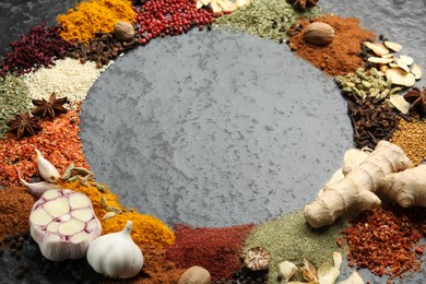 Photo of Different aromatic spices on gray textured table, closeup. Space for text